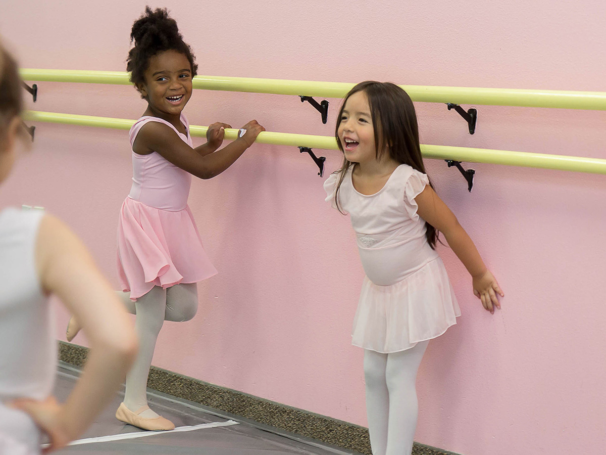 two toddler ballerinas against barre
