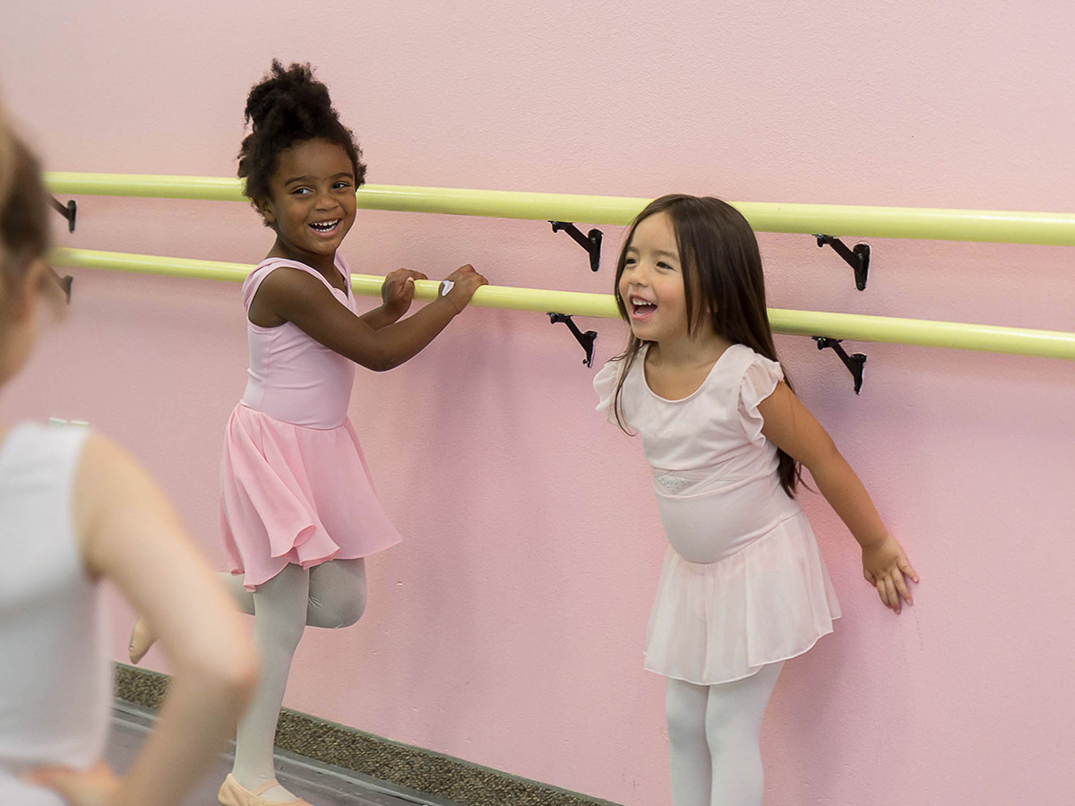 two toddler ballerinas against barre