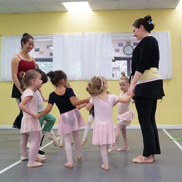 Two teachers with little girls learning about ballet